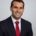 a man wearing business attire smiling at the camera