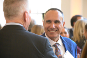 Smiling man in business attire speaking to another man